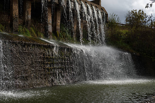 istock Waterfall in the autumn forest. Dam on the river, spillway. 2239400426