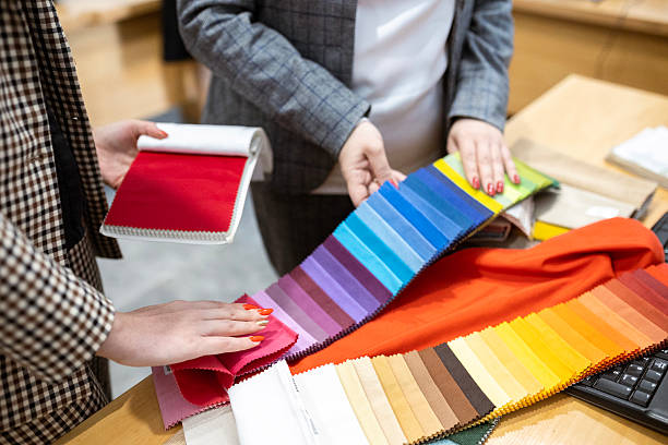 istock Two designers or a client and a decorator collaborating on a project. They are choosing from a variety of colorful fabric swatches for fashion or interior design. 2239401985