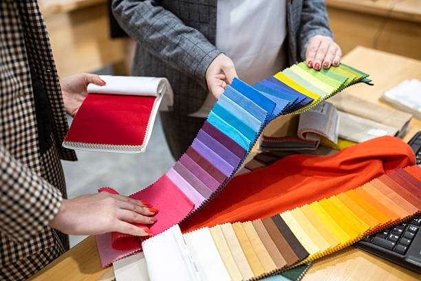 istock Two designers or a client and a decorator collaborating on a project. They are choosing from a variety of colorful fabric swatches for fashion or interior design. 2239401996