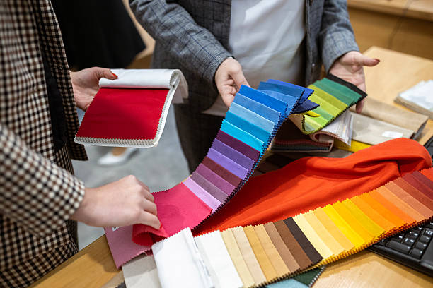istock Two designers or a client and a decorator collaborating on a project. They are choosing from a variety of colorful fabric swatches for fashion or interior design. 2239401997