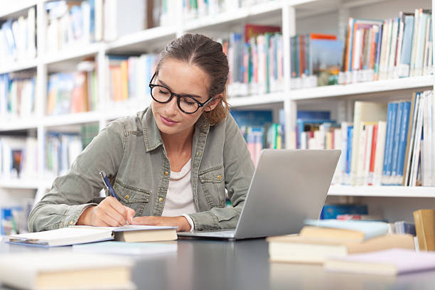 istock Young female university student studying at a desk in the college library 2239404726