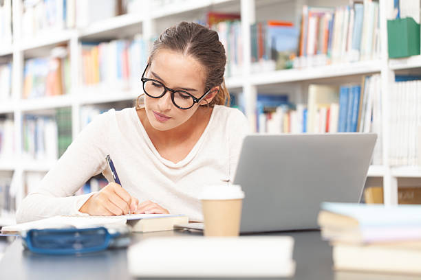 istock Young female university student studying at a desk in the college library 2239404881