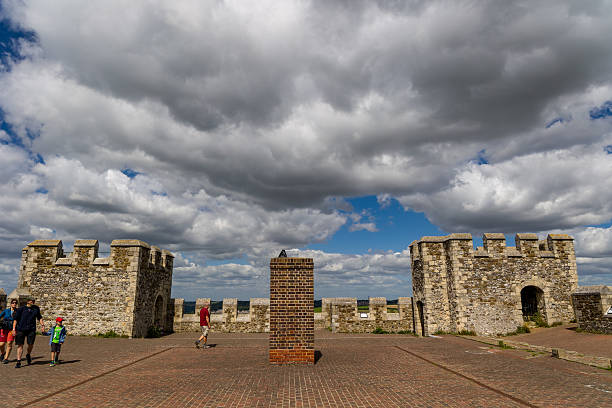 Family walking on the brick-paved roof of Dover Castle on a cloudy summer day.