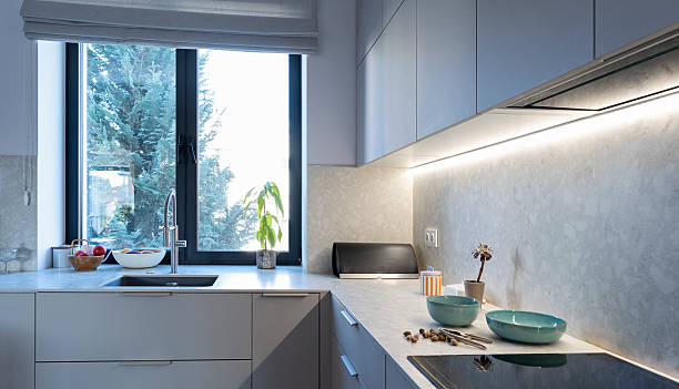 istock Home interior of kitchen with window and kitchen worktop with black stove top. Design apartment with grey furniture with cabinet. 2239411880
