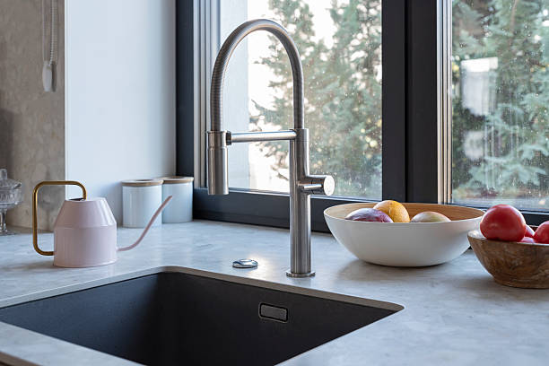 istock Kitchen sink with water tap by the window and kitchen counterpart. Home interior with modern design. 2239411885