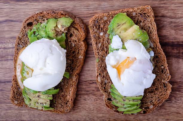 istock two whole grain sandwiches, avocado, eggs, on wooden board, top view 2239417239
