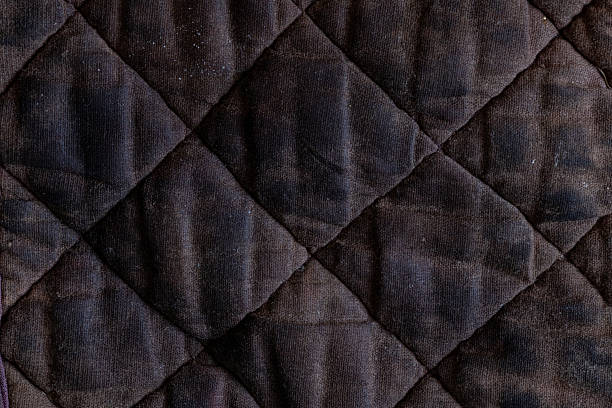 istock A dirty black cloth rag with a diamond texture, close-up view, the worn surface with creases and stains is suitable 2239418629