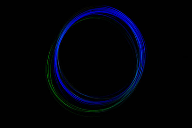 A circular display of freeze light creates a stunning visual effect in dark surroundings, showcasing bright blue and green colors.