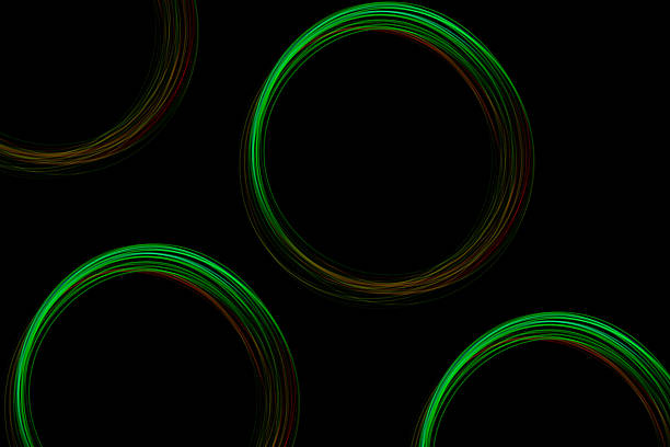 Colorful green light circles dance vividly on a black background, showcasing a captivating display of creative light art at night.
