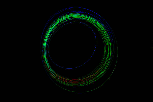 Bright green and blue lights swirl in a circular motion, creating a stunning visual effect in a dark setting.