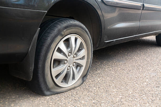 istock Black car flat tire on the road. 2239418765
