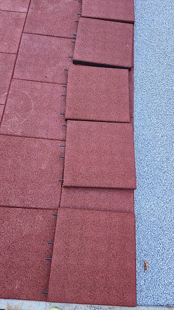 istock laying rubber crumb mats on crushed stone at a playground 2239425486