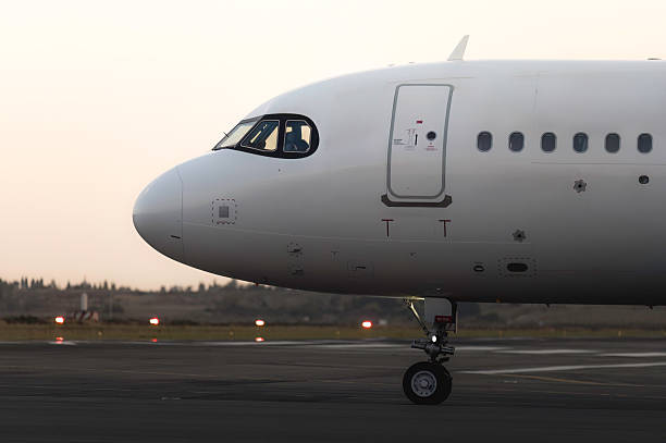 istock White passenger airplane along airport runway at dusk 2239426803