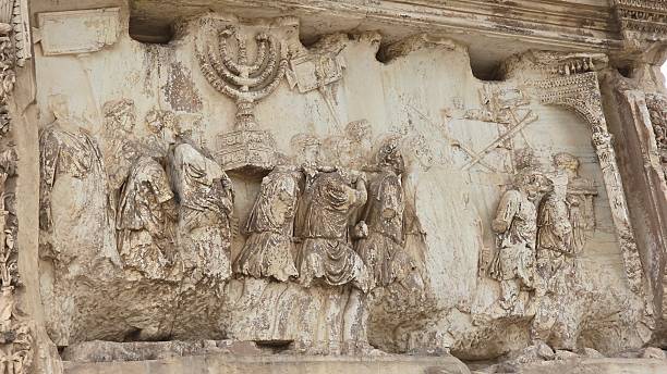 Rome, Italy - 13 January 2025. Relief on the Arch of Titus depicts Romans parading with the Temple menorah and spoils from Jerusalem after the siege in 70 CE.