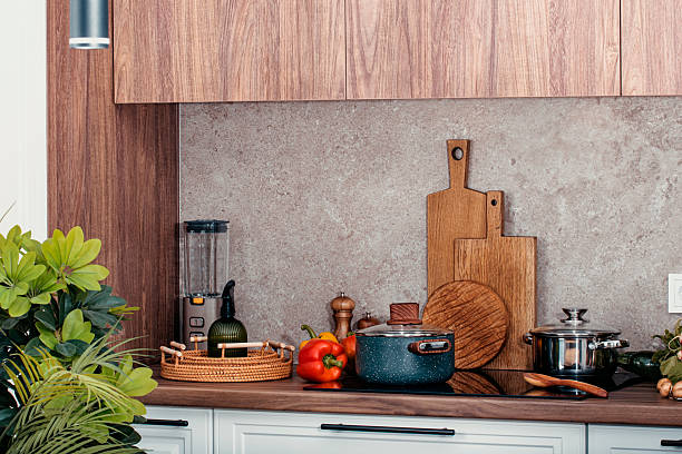 istock Kitchen countertop with utensils, pans on induction hob, bowls, cutting boards, vegetables 2239427984