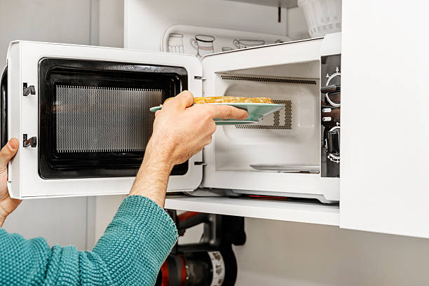 istock Putting a tortilla plate into a white microwave oven 2239430066