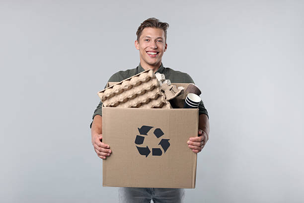 Activist caucasian man holding box full of plastic bottles for recycling environment save isolated in white. Zero waste ecology symbol for sustainable living. Eco friendly habits to protect earth.