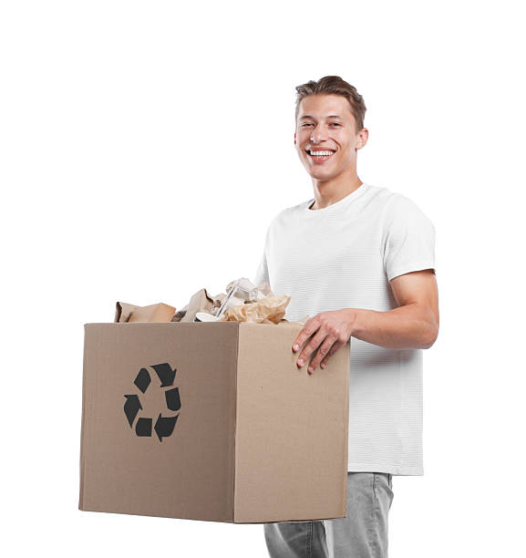 istock Recycling. Smiling man holding cardboard box with different waste paper on white background 2239437664