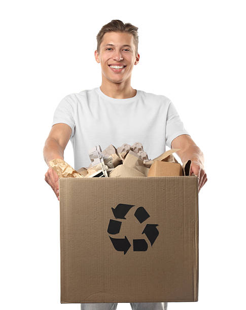 istock Recycling. Smiling man holding cardboard box with different waste paper on white background 2239437976