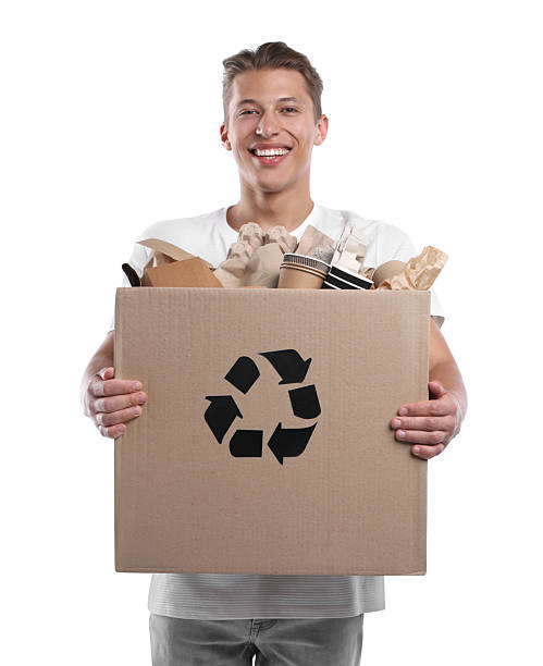istock Recycling. Smiling man holding cardboard box with different waste paper on white background 2239438062