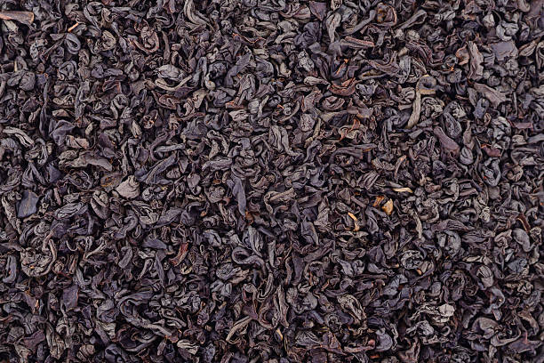 istock Loose black tea leaves isolated as background texture 2239439305