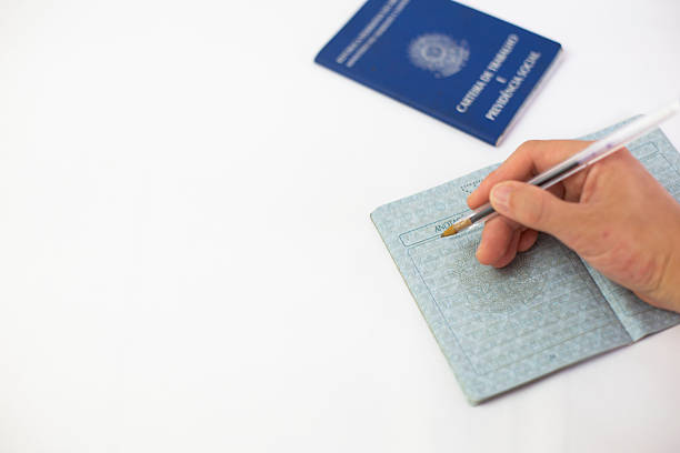 istock Hand with pen signing brazilian work card in white background 2239439978