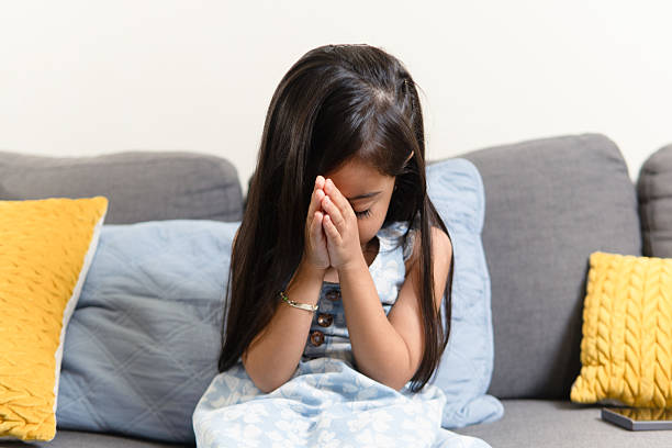 istock Young girl praying with folded hands at home 2239440929