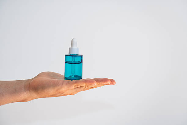 istock Blue Dermatologic Serum Dropper Bottle on Hand with White Background 2239443609