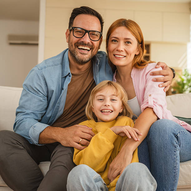 istock Parents and daughter smiling at home together 2239444451
