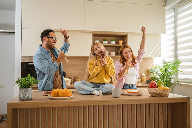 istock Happy family singing together and dancing in kitchen 2239444627