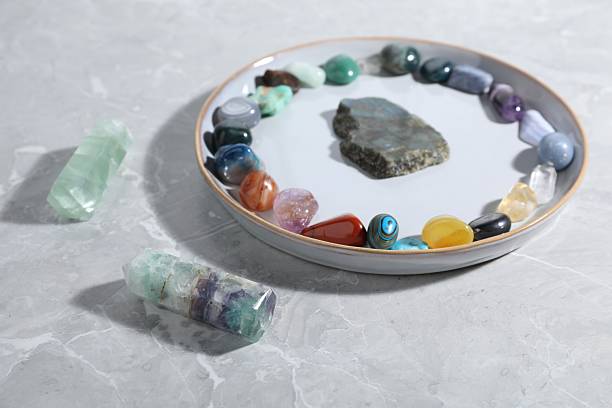 istock Many different healing stones on light grey table, closeup 2239444940