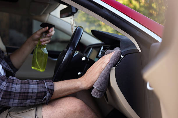 istock Man wiping car interior with grey microfiber rag in salon, closeup 2239445048