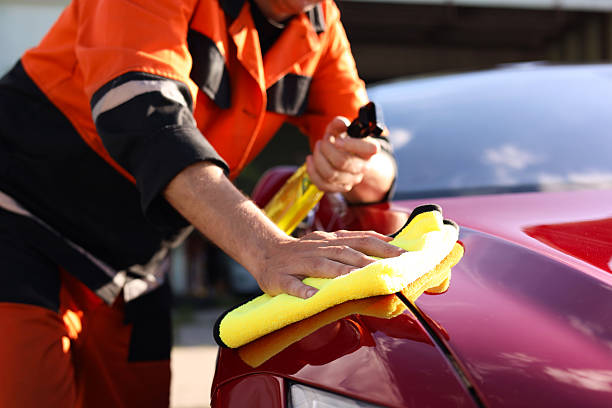 istock Man wiping car hood with yellow microfiber rag outdoors, closeup 2239445148