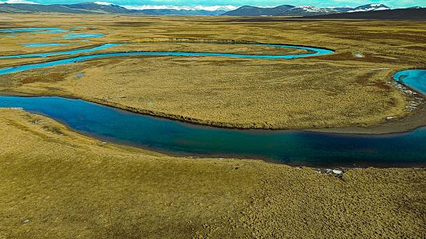 istock Menendez River meandering through grass towards snowy mountains 2239446703