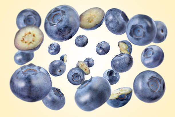 istock Fresh blueberries swirling in air against beige background 2239446864
