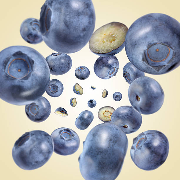 istock Fresh blueberries swirling in air against beige background 2239446930