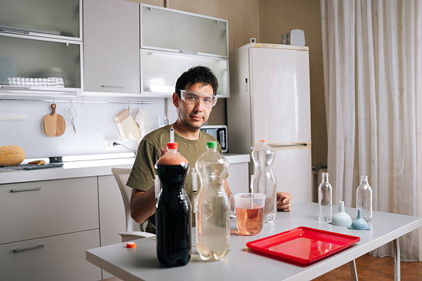 istock Agricultural technician wearing safety glasses preparing fertilizer in home kitchen laboratory, mixing various liquids and using syringe for diy gardening approach. 2239454856