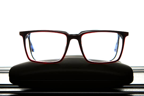 Modern red and blue eyeglasses resting on a case isolated on white background symbolizing optical style, design and visual health accessory for eyesight correction.