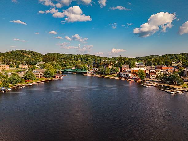 istock Scenic riverside town with boats and greenery. 2239460718
