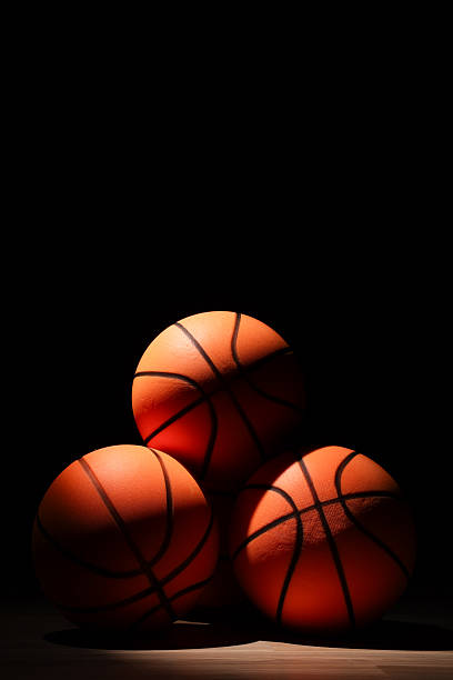 Basketballs spot lit with a black background. No People. Copy Space.