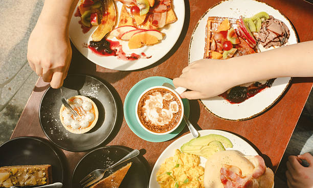 istock Morning energy, hands selecting food from sunlit breakfast setup. 2239471084