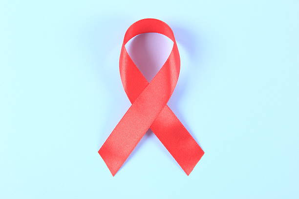 istock Aids awareness red ribbon on blue background 2239473365