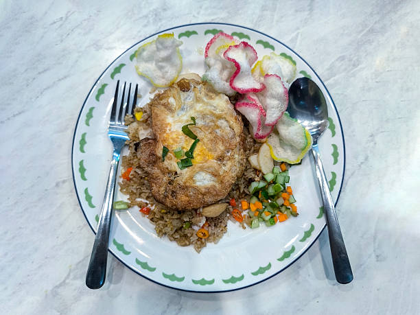 Village fried rice served on a plate, complete with crackers, eggs and pickles