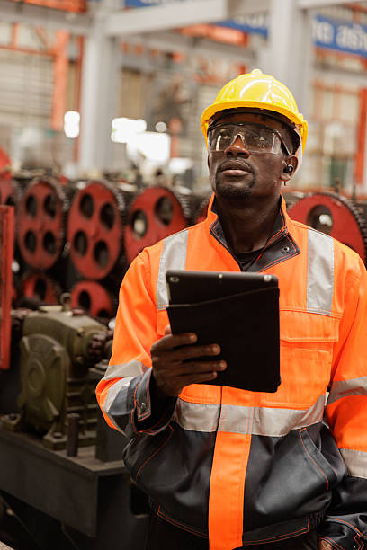 Engineer using digital tablet for machinery inspection in factory