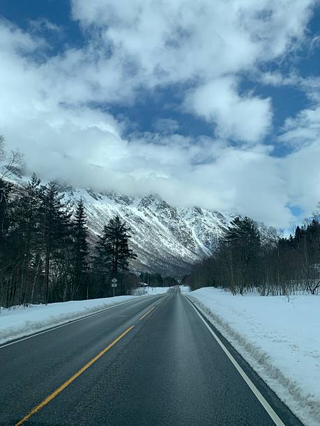 istock Winter Road Leading Toward Snow-Capped Mountains 2239479810