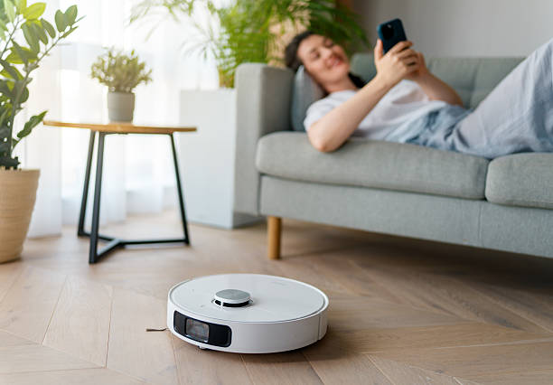 istock White robotic vacuum cleaner on wooden floor 2239484391
