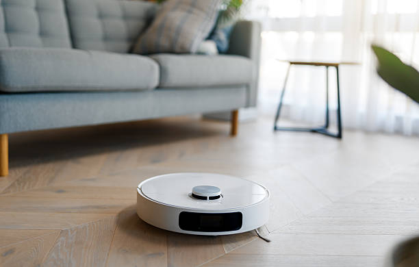 istock White robotic vacuum cleaner on wooden floor 2239484412