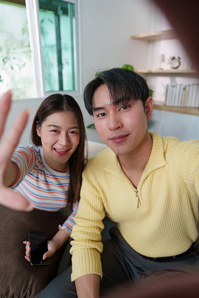 istock Cheerful young couple enjoying video call, capturing fun moments 2239484817