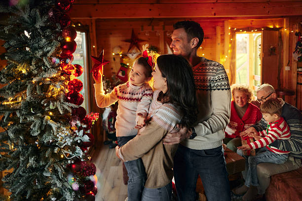 istock Happy family decorating Christmas tree at home. 2239487684