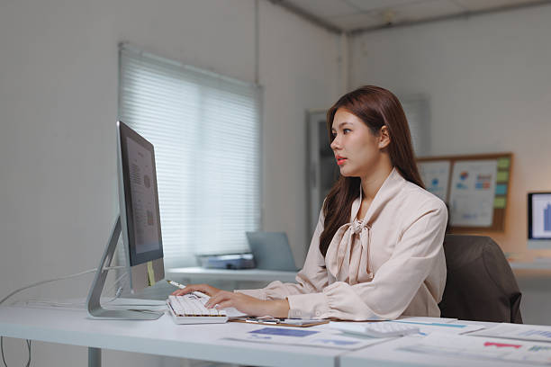 istock Asian businesswoman working late in office on computer 2239487754